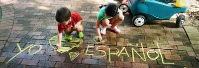 Two children celebrating Spanish with colorful chalk art